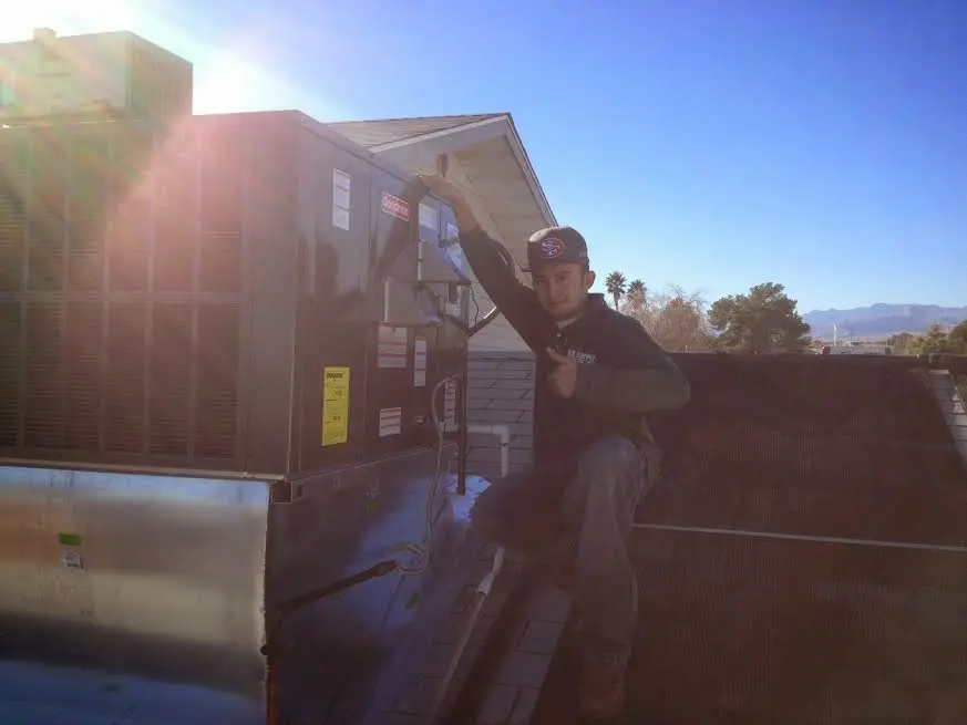 HVAC technician performing AC Tune-Up on a rooftop unit in Woonsocket